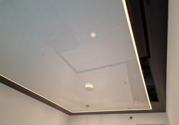 Glänzende Lackspanndecke in zwei Farben mit modernen Lichtlinien als Hauptbeleuchtung