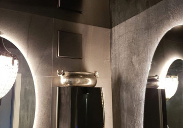 Foto einer glänzenden schwarzen Lackspanndecke mit Wandbeleuchtungsspiegelung.