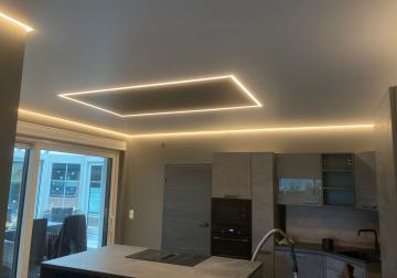 Moderne Spanndecke in der Küche mit umlaufender Lichtlinie und quadratischer Deckenbeleuchtung