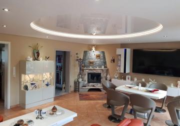 Moderne Spanndecke mit zwei Ebenen und stilvoller indirekter Beleuchtung im Wohnzimmer